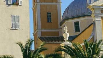 A building with a prominent bell tower and a dome, surrounded by palm trees.