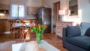 Un salon confortable avec un canapé et un coin repas comprenant une table et des chaises.