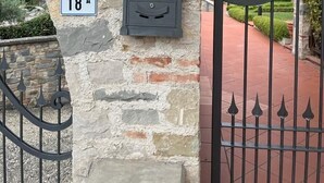 Kivestä rakennettu sisäänkäynti, jossa on kyltti, jossa lukee ”Residence I MOLINI”, sekä postilaatikko.