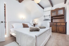 Ein Schlafzimmer mit Bett, Nachttischen, einem Kleiderschrank und einer Wandleuchte.