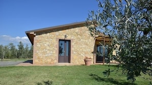 A stone building with a door and windows, surrounded by grass and trees. - Detached house, stone, 6 pax, garden, wonderful sea view (Casale Marittimo)