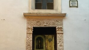 A building entrance with an ornate doorway and a small window above.