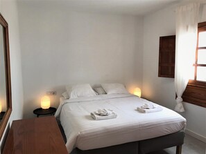 A neatly made bed with white linens and two towels folded at the foot. - Stunning front line 2 bedroom apartment (Tías)