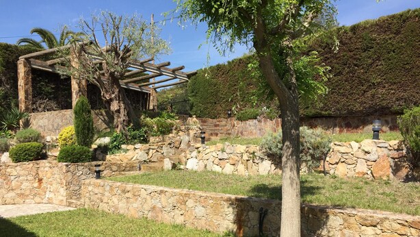 A stone pathway leading to a wooden pergola with climbing plants. - Secluded house with pool, barbecue and garden 10min. of the beach. Ideal families (Calonge)