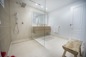 Een bad/douchecombinatie, een haardroger, handdoeken, toiletpapier