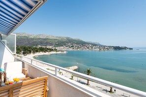 A balcony with a view of a coastal town, a beach, and a clear sky. - DUPLEX apartment with SEA VIEW only 10 meters from the sea! (Stobrec)