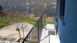 A balcony with a view of a lake and mountains. - LAKE ORTA - LAKE VIEW APARTMENT, PRIVATE BEACH AND BALCONIES (FIRST FLOOR) (Pettinasco)