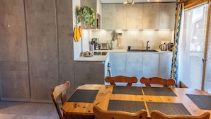 Una cocina moderna con una isla central, sillas de madera y una mesa de comedor.