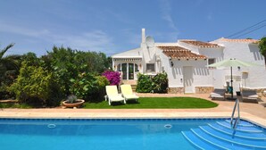 A pool with lounge chairs and a white building with a tiled roof. - Detached Villa Close to Arenal Beach, Javea -Stunning, Very Private Villa & Pool (El Tosalet)
