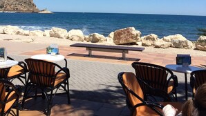 An outdoor seating area with tables and chairs facing a beach. - Detached Villa Close to Arenal Beach, Javea -Stunning, Very Private Villa & Pool (El Tosalet)