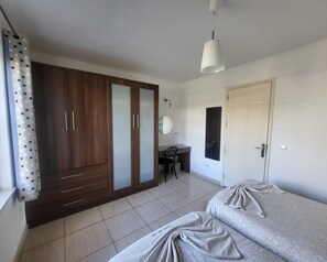 Ein Schlafzimmer mit Bett, Schrank, Schreibtisch und Stuhl.