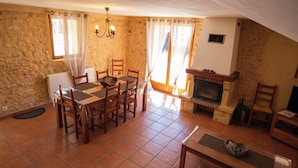 A dining area with a table and chairs, a fireplace, and a stone wall. - Character house in the heart of the Luberon Park (Gargas)