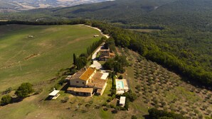 An aerial view of a rural property with a farmhouse, a swimming pool, and surrounding fields. - Country House & Spa - Inside Nature with panoramic views, Art Surrounded (Volterra)