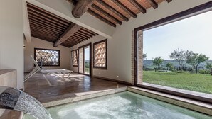 A spacious indoor pool area with a clear view of the outdoors, a water feature, and a wooden ceiling. - Country House & Spa - Inside Nature with panoramic views, Art Surrounded (Volterra)