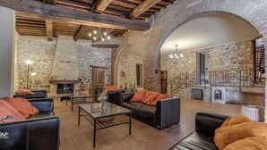 A rustic interior with stone walls, leather sofas, a fireplace, and a staircase. - Country House & Spa - Inside Nature with panoramic views, Art Surrounded (Volterra)