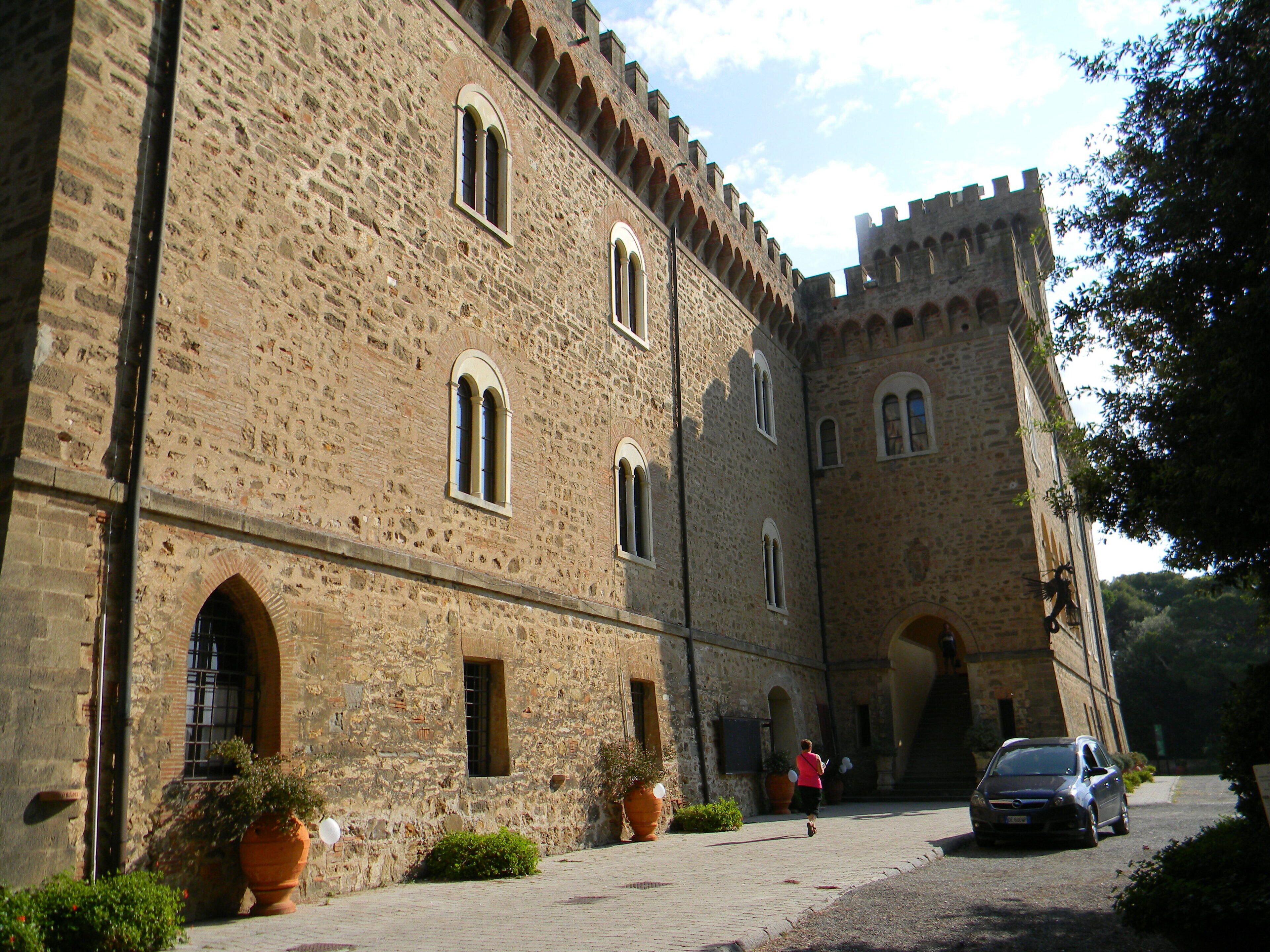 A historic stone building with arched windows and a fortified tower.