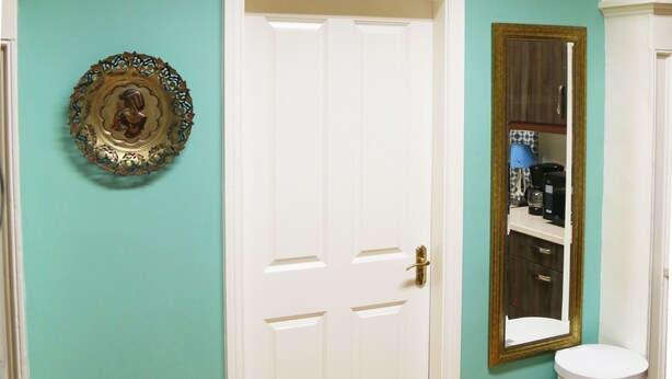 A room with a white door, a small trash bin, and a mirror on the wall. - Perfect! for doing Galway City - sleeps 2+, walk everywhere... (Devon Place The Crescent Galway City)