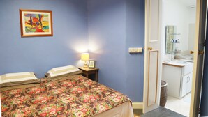 A room with a bed, a nightstand, a lamp, a framed picture, and a bathroom visible through an open door. - Perfect! for doing Galway City - sleeps 2+, walk everywhere... (Devon Place The Crescent Galway City)