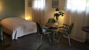 A room with a bed, a dining table with chairs, a vase with flowers, and curtains. - Cottage in the countryside, less than 10 minutes from Mulhouse center, near Switzerland (Steinbrunn-Le-Bas)