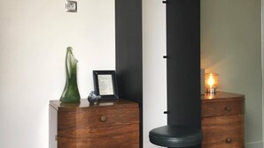 A modern room with a black column, wooden side tables, and a green vase. - Cottage in the countryside, less than 10 minutes from Mulhouse center, near Switzerland (Steinbrunn-Le-Bas)