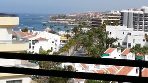 A coastal cityscape with buildings, palm trees, and the sea. - 1 Bed Hotel Apt. in Costa Adeje, Few minutes walk to Beach, Shops & Restaurants (Costa Adeje)