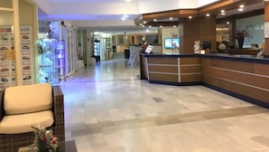 A hotel reception area with a reception desk, a seating area with a chair, and a display of car models. - 1 Bed Hotel Apt. in Costa Adeje, Few minutes walk to Beach, Shops & Restaurants (Costa Adeje)