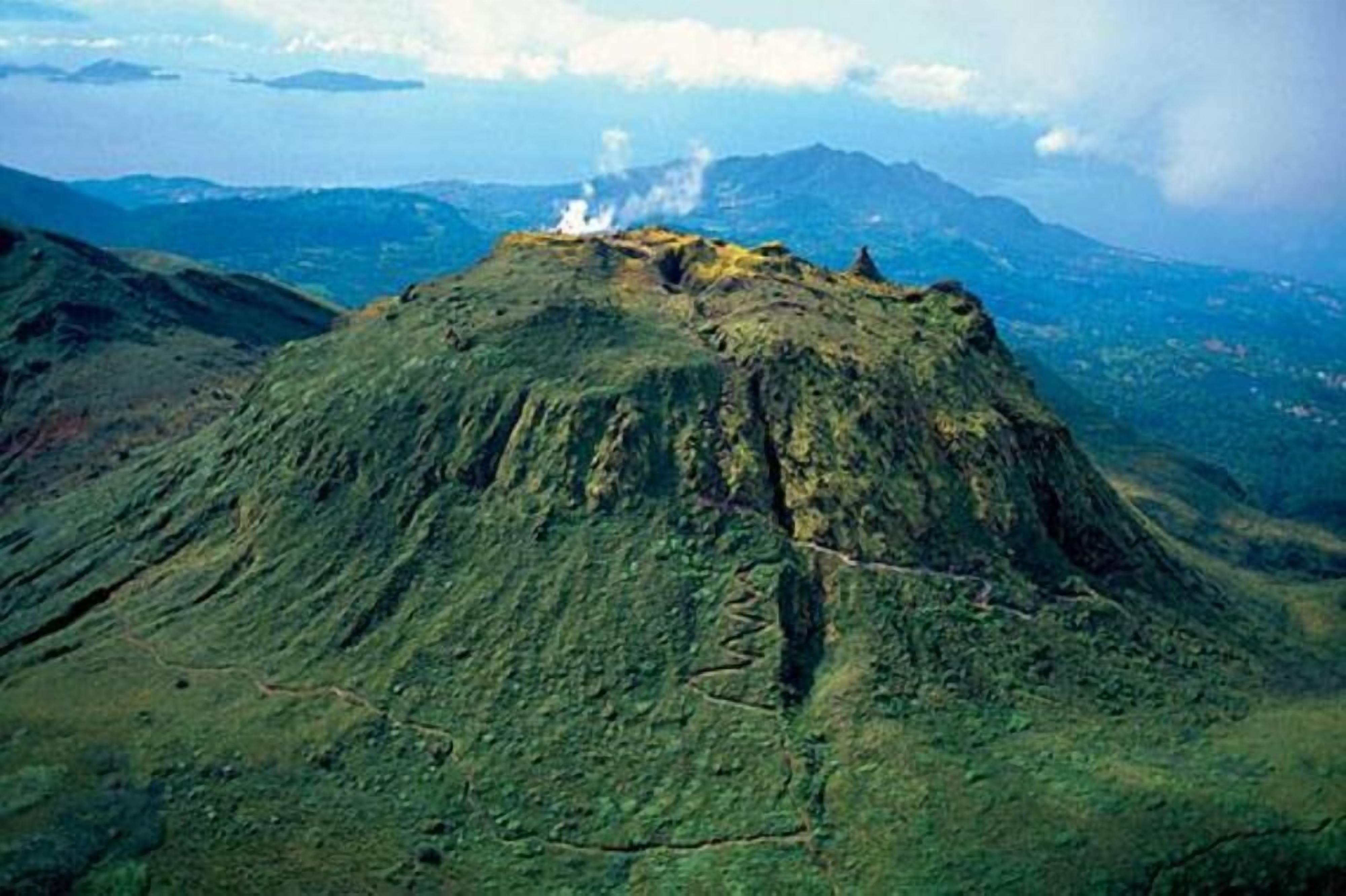 Un paysage volcanique caractérisé par un sommet imposant et un sentier bien visible.