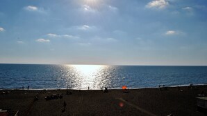 A beach with people, a sun, and the ocean.