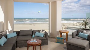 A balcony with a view of the beach, wicker furniture, and a table with a bottle and glasses. - CELESTINE, beach front villa with roof top pool and spectacular views. (Kolymvari)