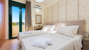 A hotel room with two beds, a balcony, and a view of the city.