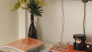 Een bureau met een bloemenvaas, een stapel tijdschriften, een klein glas en een koffiekop.