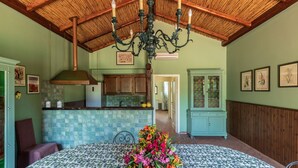 A dining area with a patterned tablecloth, a floral centerpiece, and a wooden ceiling.