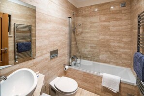 Een bad/douchecombinatie, een haardroger, een bidet, handdoeken