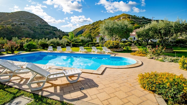 A swimming pool with lounge chairs, surrounded by landscaped gardens and a mountainous backdrop. - B&B room with swimming pool (Gasponi)