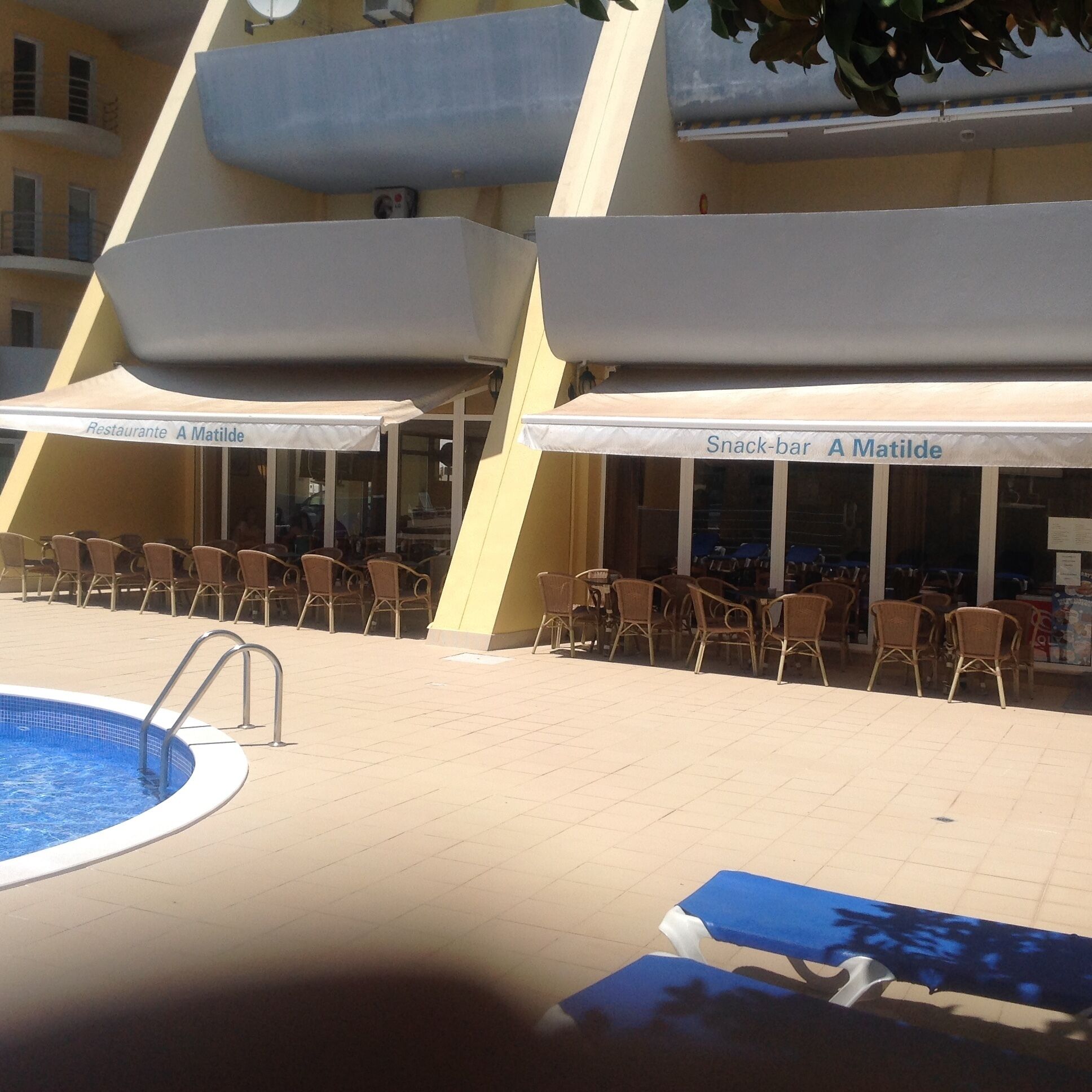 A pool area with lounge chairs and umbrellas labeled 'Restaurant A Matilde' and 'Snack-bar A Matilde'.