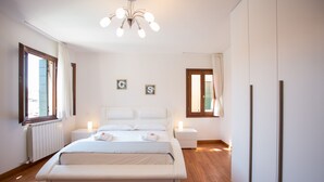 A modern bedroom with a large bed, bedside tables, and a ceiling light fixture. - Venice Appartament Salini II (Venezia)