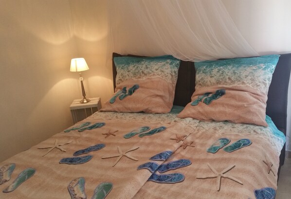A bed with a beach-themed bedspread, a bedside lamp, and a canopy. - Modern Villa, Pool, Air Cond., Veranda, BBQ, outdoor Kitchen, outrdoor Shower (Ostuni)