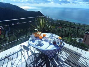 A table set with breakfast items on a balcony overlooking a coastal landscape. - B&B Il Vigneto with a view of the sea in the Cinque Terre National Park (Riomaggiore)