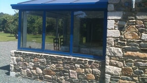 Un bâtiment en pierre avec un toit bleu et de grandes fenêtres.