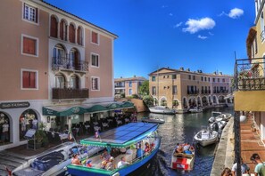 A canal with boats, a restaurant named 'Pasta', and buildings with balconies.