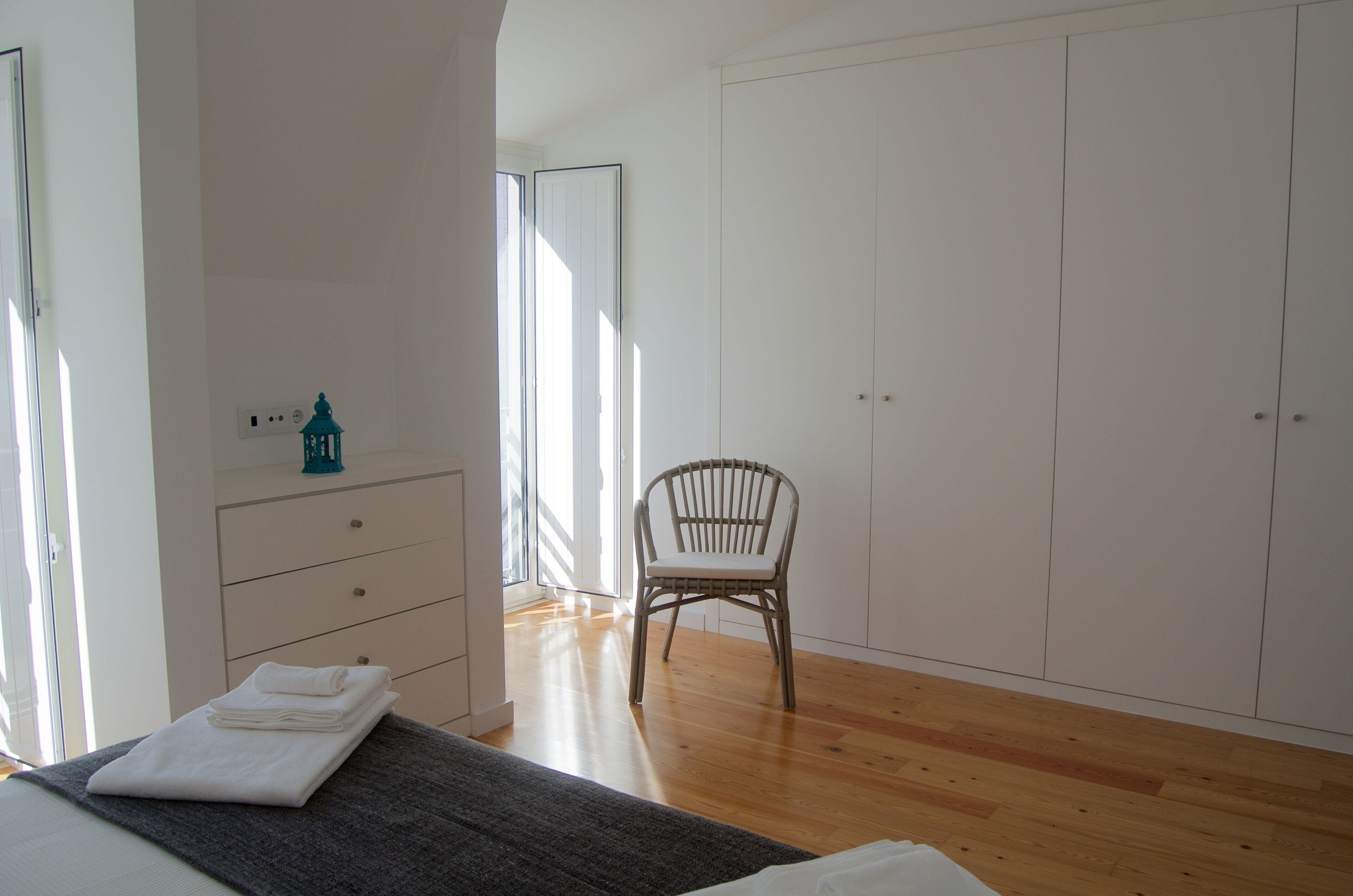 Une chambre à coucher comprenant un lit, une commode, une chaise et une armoire.
