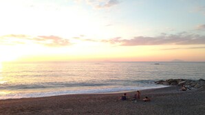 A beach with a sunset, calm sea, and people relaxing. - Farmhouse with pool between oranges and lemons trees (Mirto)
