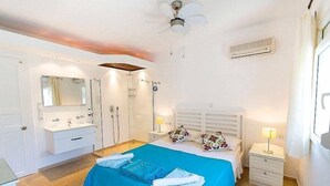 A bedroom with a bed, a nightstand, a mirror, a vanity, and a ceiling fan. - Villa With Private Heated Pool(optional extra) And Sea Views (Kalkan)