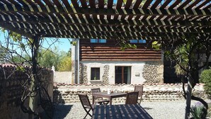 A rustic stone building with a tiled roof, a wooden pergola overhead, and a table with chairs in front. - Peaceful private base in Pyrenees, large pool, perfect for outdoor enthusiasts (Thuy)