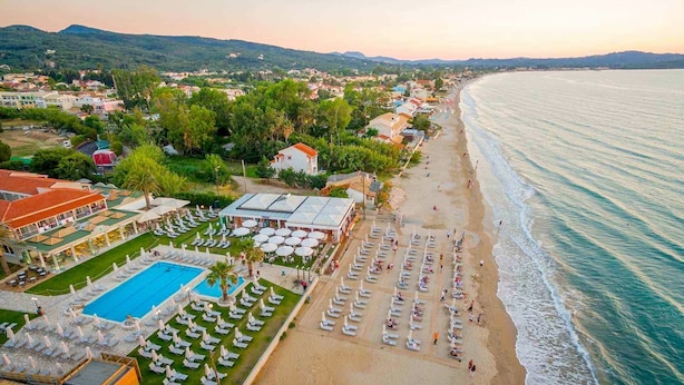 An aerial view of a coastal resort with a swimming pool, beach chairs, and umbrellas. - Acharavi Beach Villa - Luxury Seaside Villa Rental in Acharavi, Island of Corfu. (Acharavi)