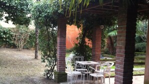A covered outdoor seating area with brick pillars and metal chairs. - 5 MINUTES FROM THE S. LUCIA TRAIN STATION (Venezia)