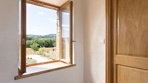 Une pièce dotée d’une porte en bois et d’une fenêtre donnant sur un paysage verdoyant.