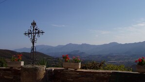 A view of a mountainous landscape with a stone wall and potted plants with red flowers. - Apartment/ flat - Pieve (Piève)