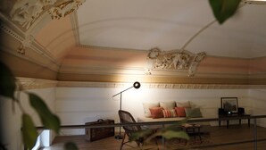 Una habitación con un sofá, una lámpara y un cuadro en una mesa.