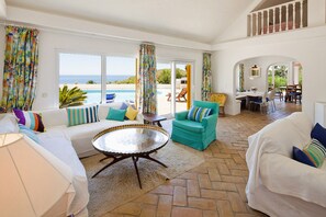 Un vaste espace de vie avec vue sur la mer, un coin repas et un balcon avec piscine.